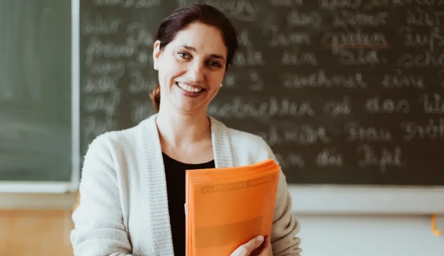 Smiling teacher with orange book